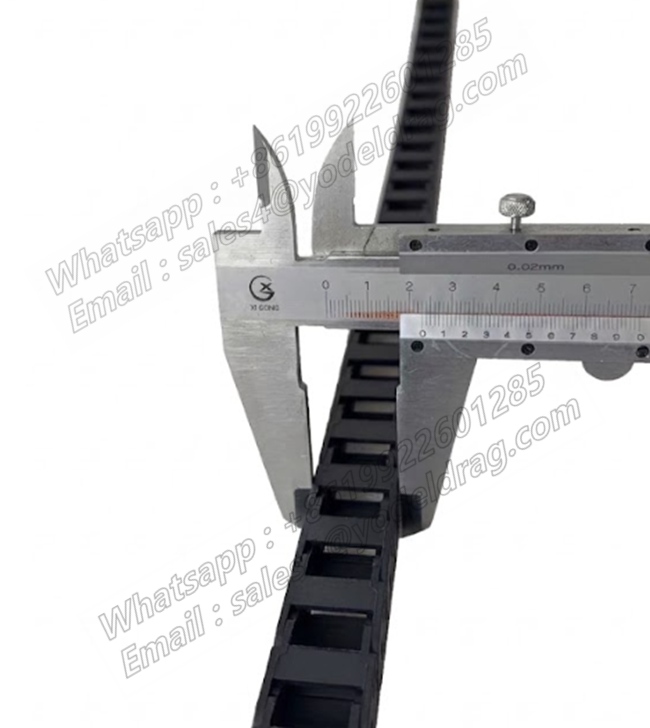 Vernier caliper measuring the precise width of a non-openable PA66 miniature cable carrier for micro automation