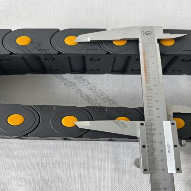 Checking bending clearance and height dimensions of enclosed CNC cable chain for machine tools.
